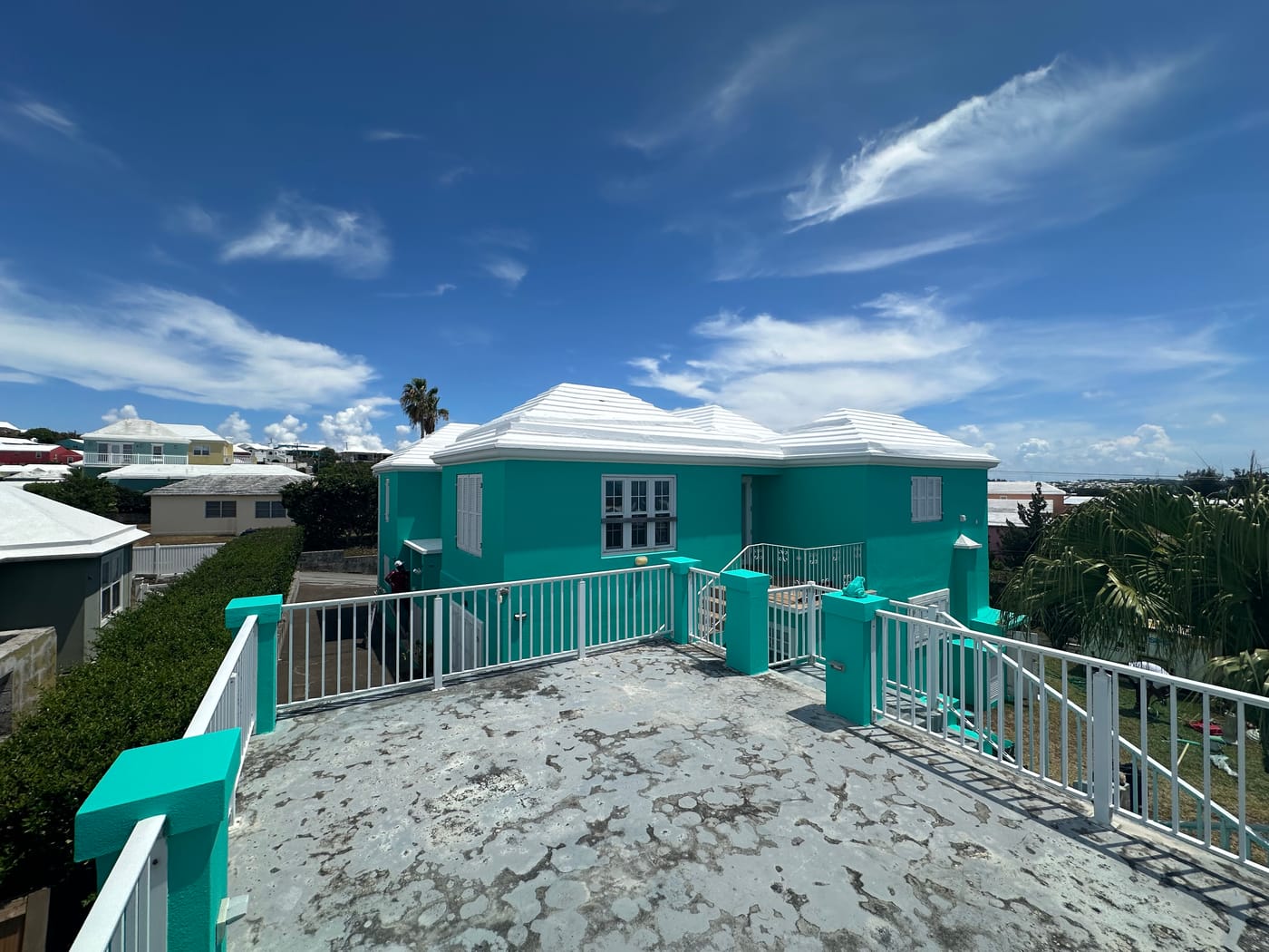 Bermuda home repainted turquoise with a freshly coated white roof