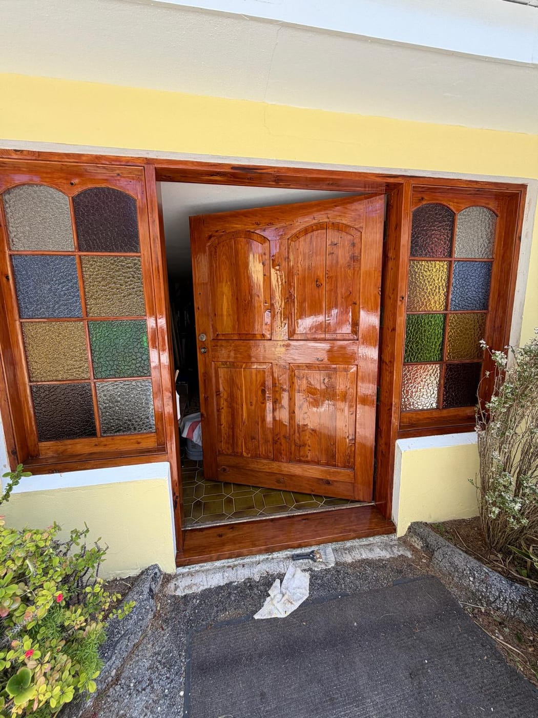 Cedar entry door with stained-glass sidelights, freshly coated